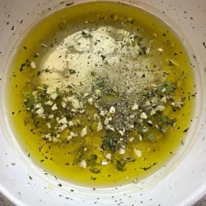 large_bowl_whisk_together_olive_oil_lemon_juice_minced_garlic_oregano_salt_and_pepper
